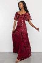 Back view of Karina sequin maxi dress in wine featuring smocked back bodice and fully lined skirt with sheer sleeves.