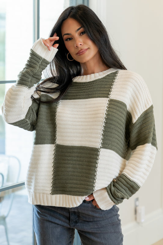 Detail shot of the Jayda sweater neckline and shoulder area, showing the round neck, stitch work, and the soft drape of the acrylic knit.
