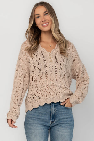 Oatmeal pointelle knit sweater with a scalloped henley neckline, functional button front, dropped shoulders, long sleeves, and a scalloped hem.