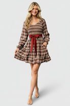 Back view of Stina Short Dress showing elastic waistline, smocked back detail, and the plaid pattern across the skirt panels.