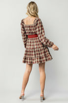 Side view of model wearing Stina Plaid Mini Dress with sash tied at waist and two-tiered skirt movement visible.