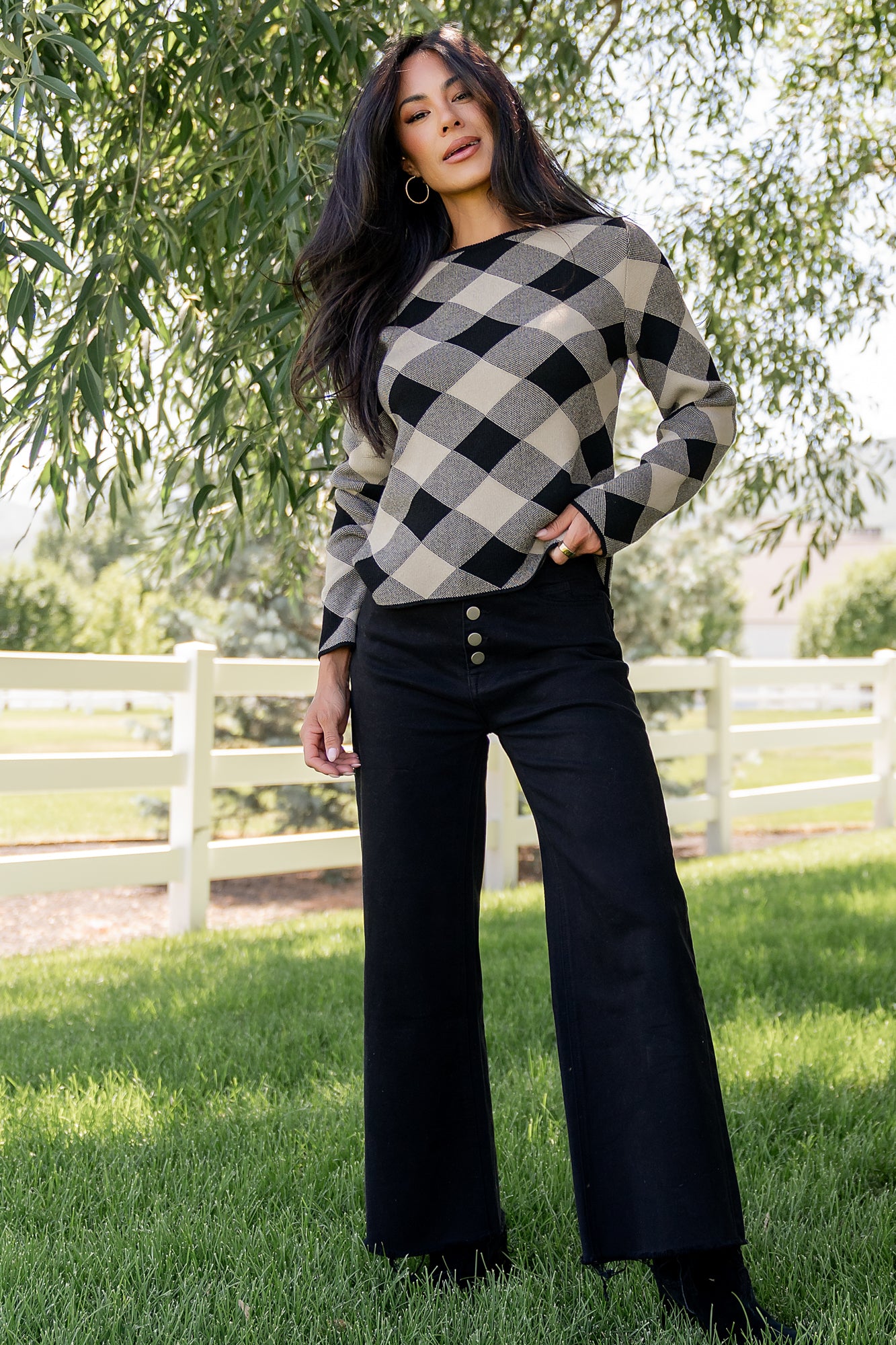 Front view of Linnea argyle sweater in black and natural on model, showing boat neckline, ribbed cuffs, and straight hem for everyday wear.