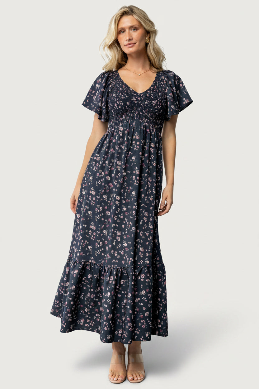 Front view of Jerah Smocked Midi Dress in Midnight Floral on model; smocked bust, wide V-neck, and flowy tiered skirt.