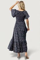 Side view highlighting hidden side pocket and flowing single-tier skirt on the Midnight Floral Jerah Dress.