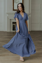 Model walking to show skirt movement and left leg slit, showcasing chiffon drape and the dress’s flowing maxi length.