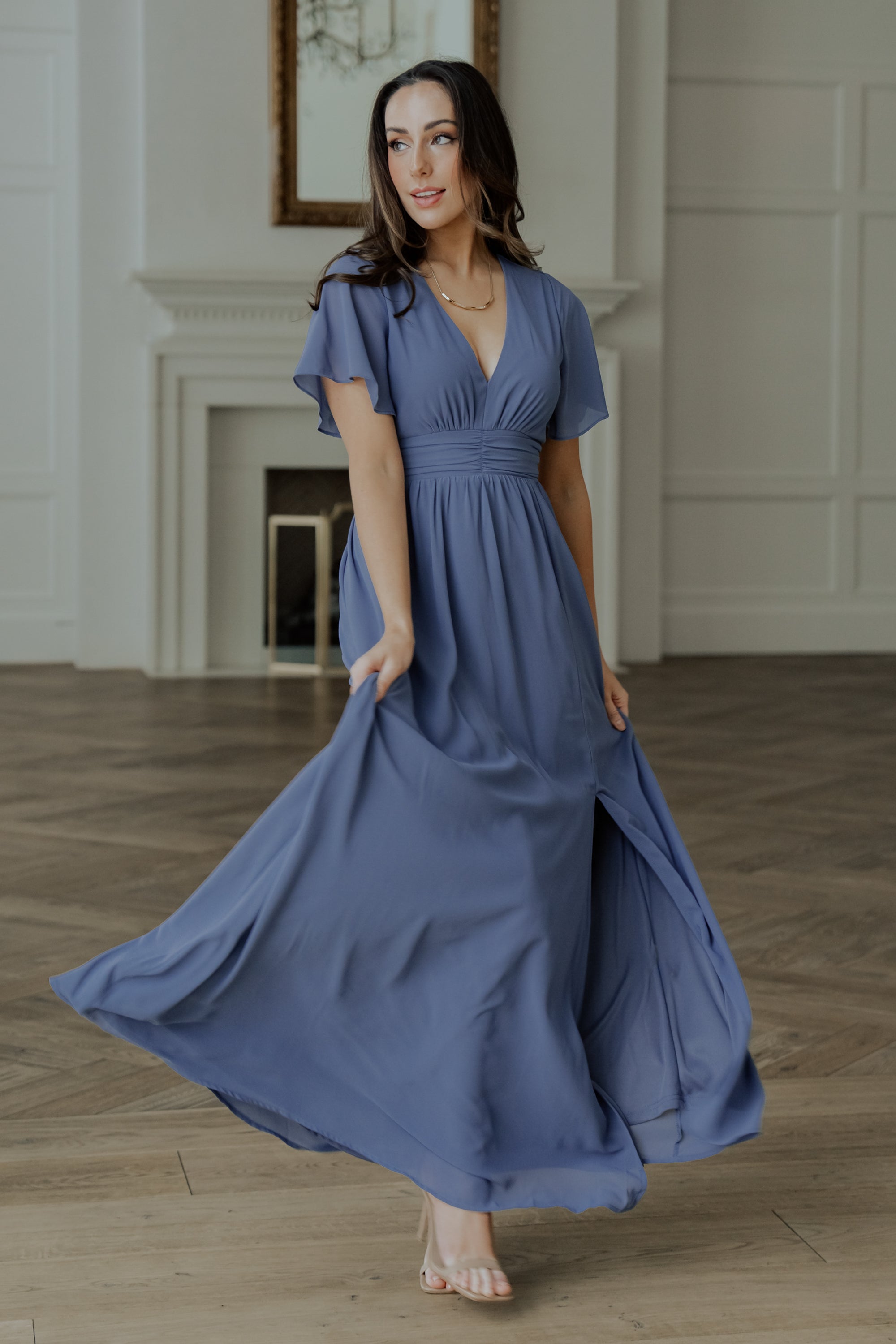 Model walking to show skirt movement and left leg slit, showcasing chiffon drape and the dress’s flowing maxi length.