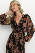Close-up of printed chiffon fabric showing delicate mauve floral pattern on a black ground and soft lightweight texture.