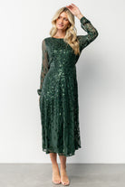 Model wearing the Kalla sequin midi dress in emerald, full-length view showing A-line skirt, fit, and styling with simple heels.
