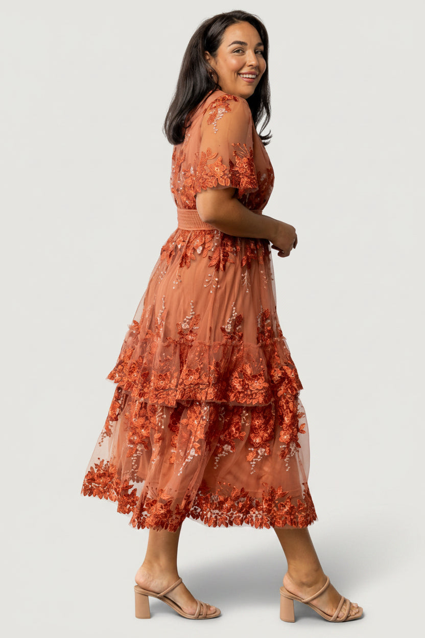 Fabric texture close-up showing embroidered motifs on fine tulle and the lined body fabric beneath for coverage and comfort.