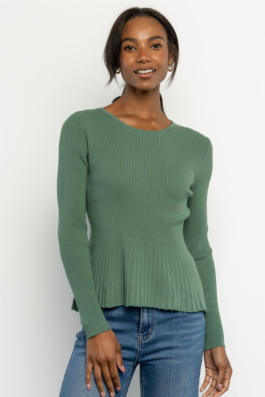 Model wearing a winter green ribbed peplum top with fitted bodice and round neckline, styled with high-rise jeans for a casual look.
