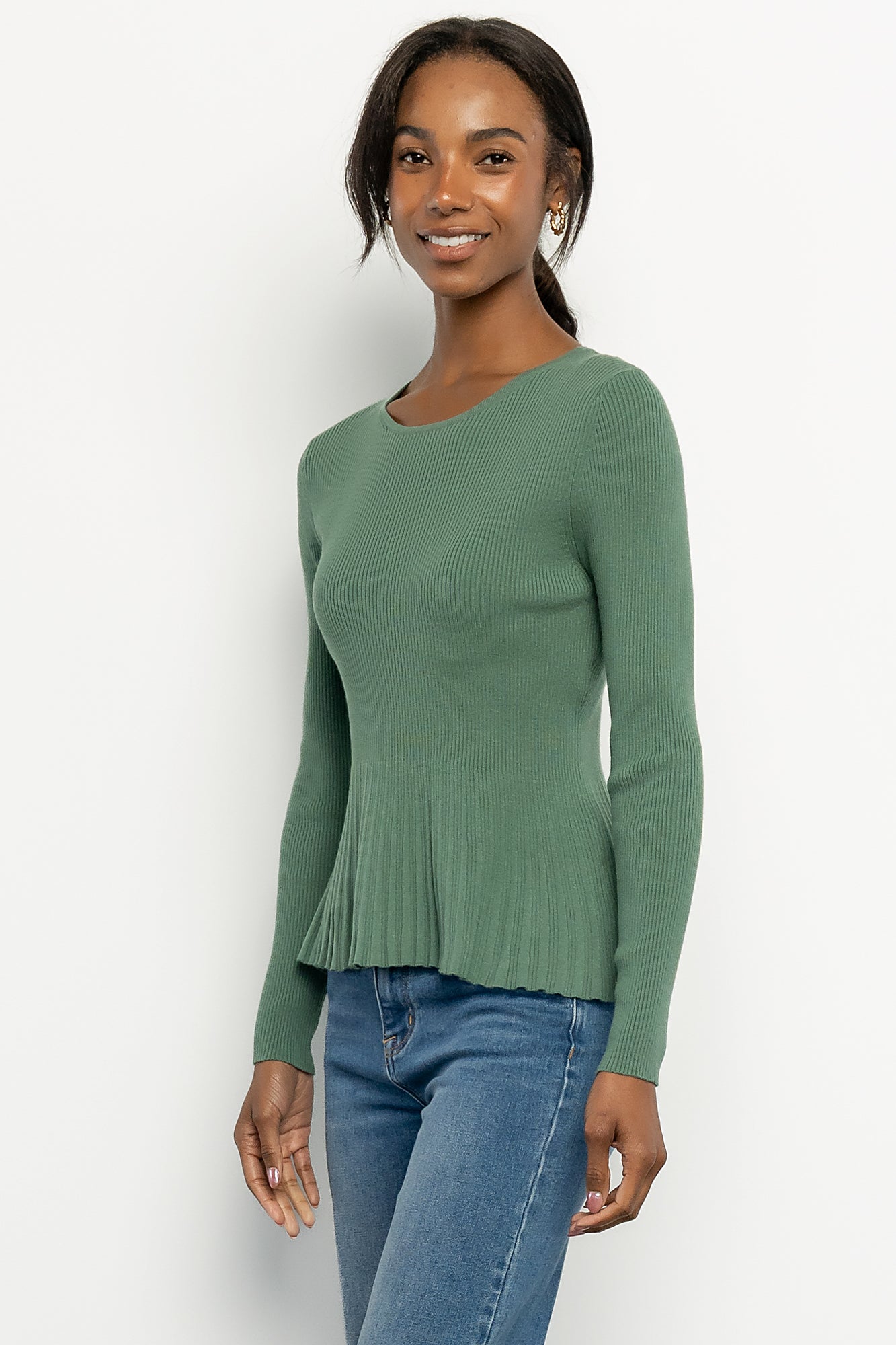 Styled outfit photo: winter green ribbed top paired with jeans and booties, showing overall fit and everyday styling options.