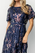 Three-quarter view of Muse Sequin Maxi Dress in dark blue multi highlighting short sheer sleeves, keyhole back detail, and shimmering sequins.