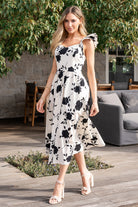 Three-quarter view of the midi dress on a model, showing the skirt length, partial lining, and discreet side pockets.