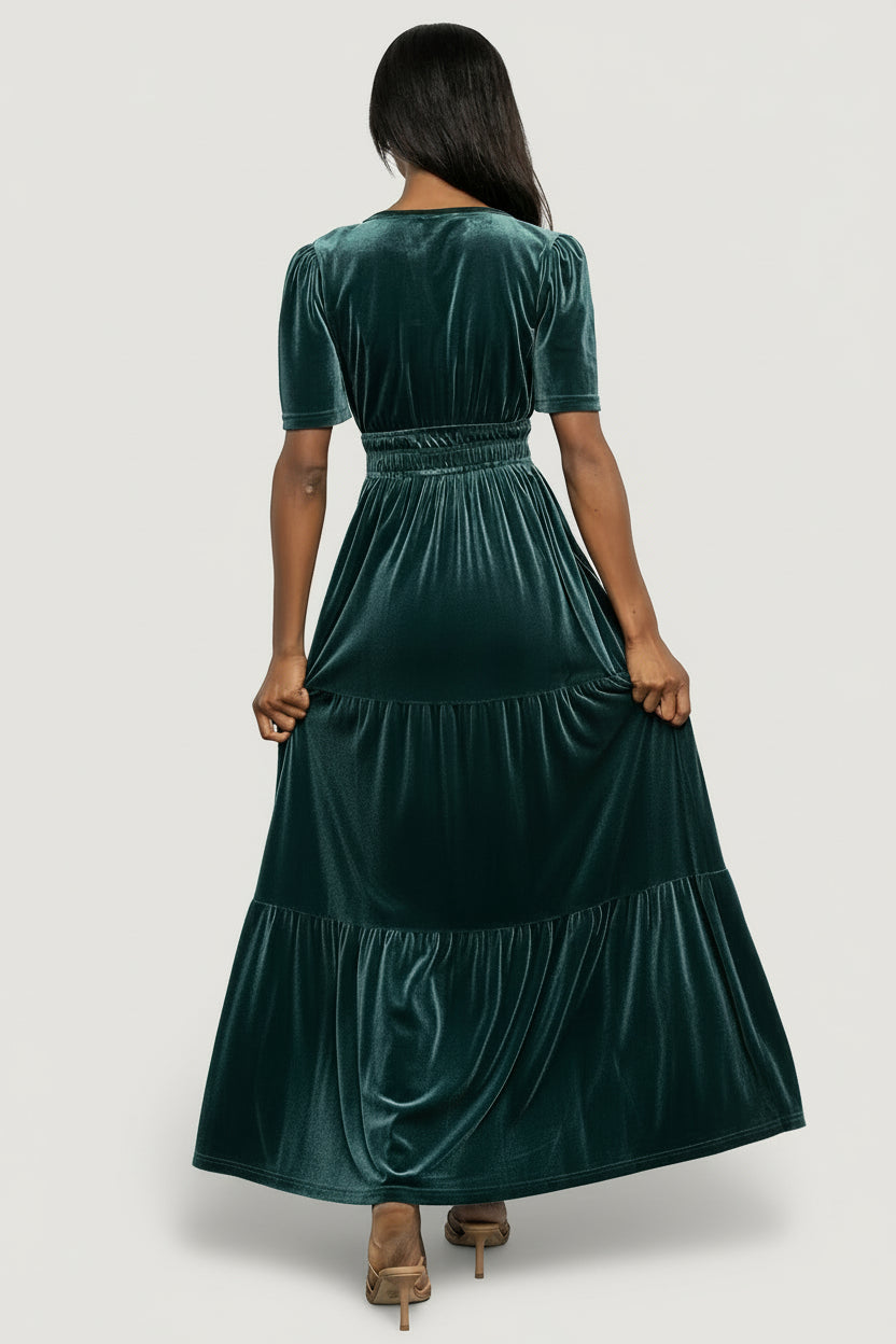 Model wearing the Artemis Deep Lagoon velvet maxi dress, full-length view that emphasizes movement and the tiered skirt.