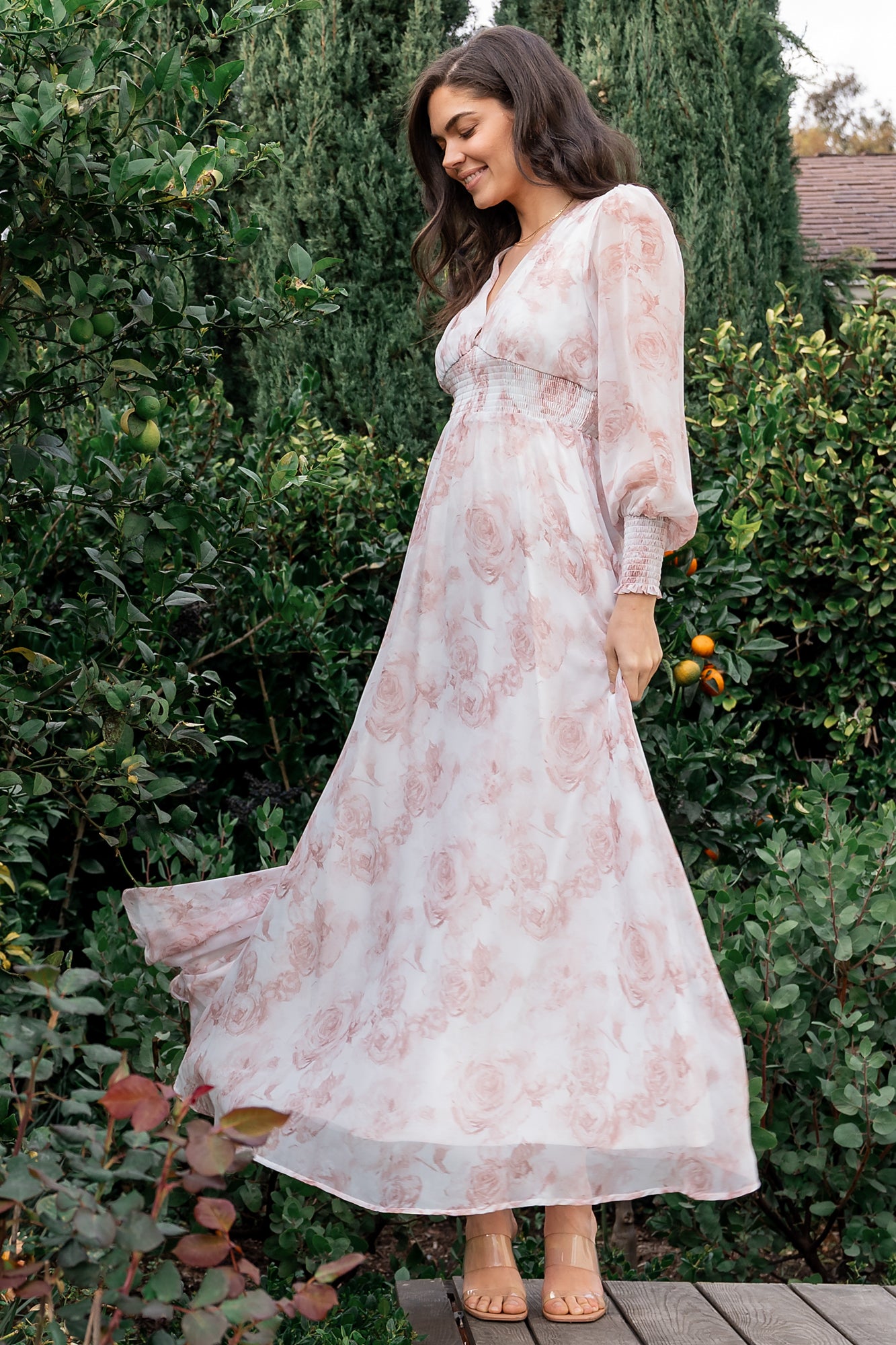 Close-up of pink floral chiffon fabric and smocked waist detail, highlighting the printed pattern and lightweight drape of the skirt.