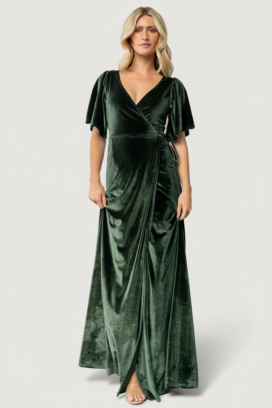 Close-up of deep-green velvet fabric and waist tie on the Meghan wrap maxi dress, showing texture and subtle stretch in the material.
