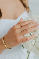The Emma Ring displayed on a white surface, showing reflective gold-plated links and fine craftsmanship in close detail.