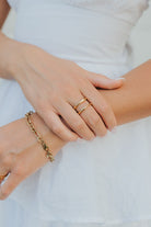 Lifestyle image of the Florence ring paired with a Hannah bracelet on a textured background, showing wearable scale and polished detailing.