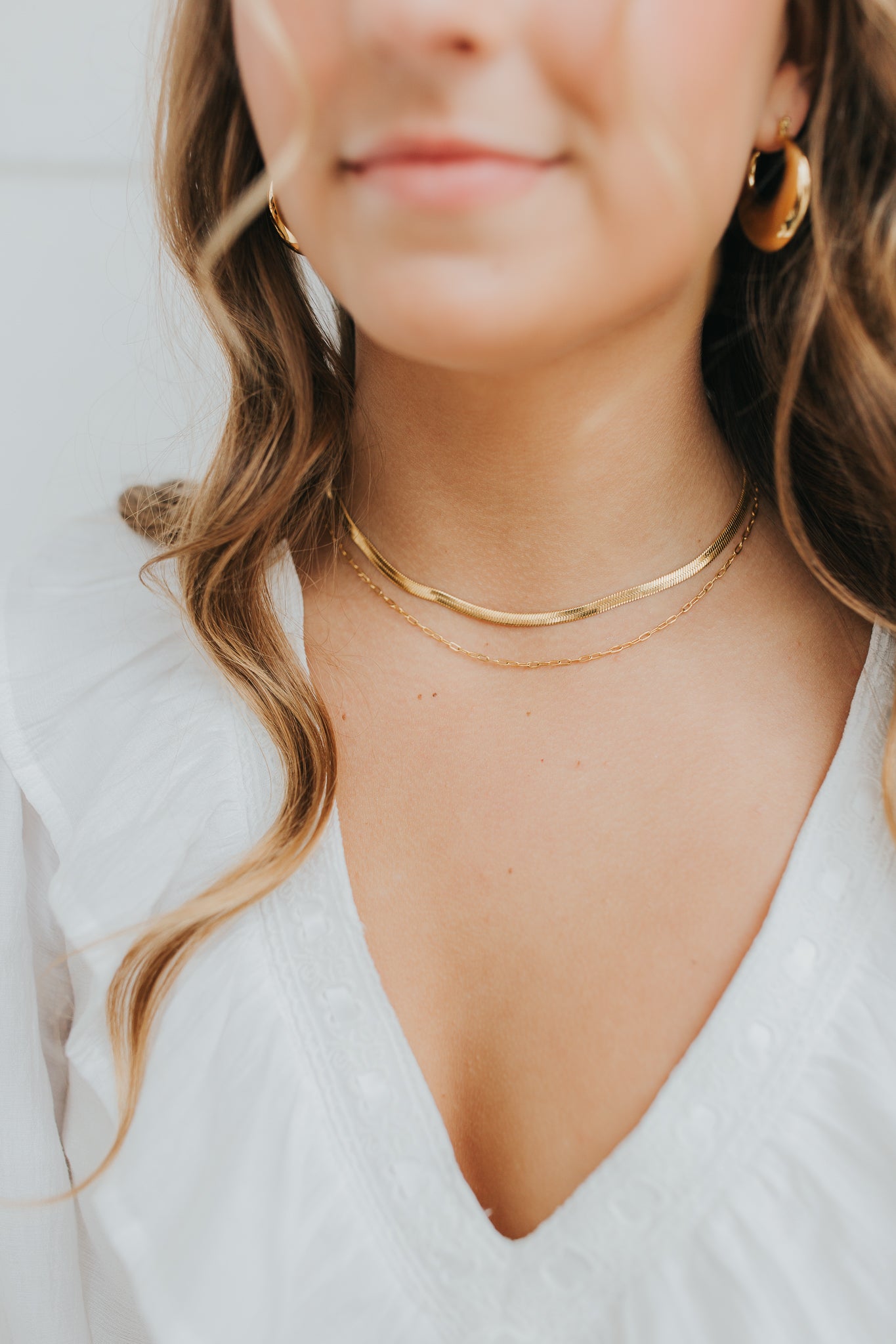 Styled flat-lay of the Christina necklace showing both chains attached at the clasp, lobster closure, and extender for adjustable length.