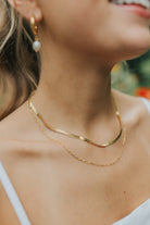 Close-up of the Christina layered double-chain necklace in warm gold, showing both fine chains, lobster clasp, and delicate finish on white background.