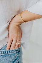 Model wrist shot wearing the Lily Bracelet to show scale and how the lightweight bangle layers with other jewelry.