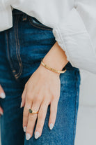 The Maddie emerald ring styled with delicate bracelets to show scale and how it layers with other jewelry pieces.