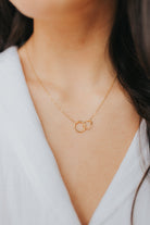 Artist-view image of The Mia Necklace highlighting the contrast between the smooth and textured gold circles and adjustable clasp.