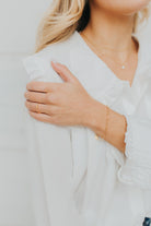 Styled shot of Eloise Link Bracelet paired with rings, showing layered wear and the bracelet's polished gold-plated finish against skin tone.