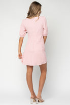 Angled side view of the pink stripe mini dress on a model showing silhouette, short length, and how the lined front bodice fits.