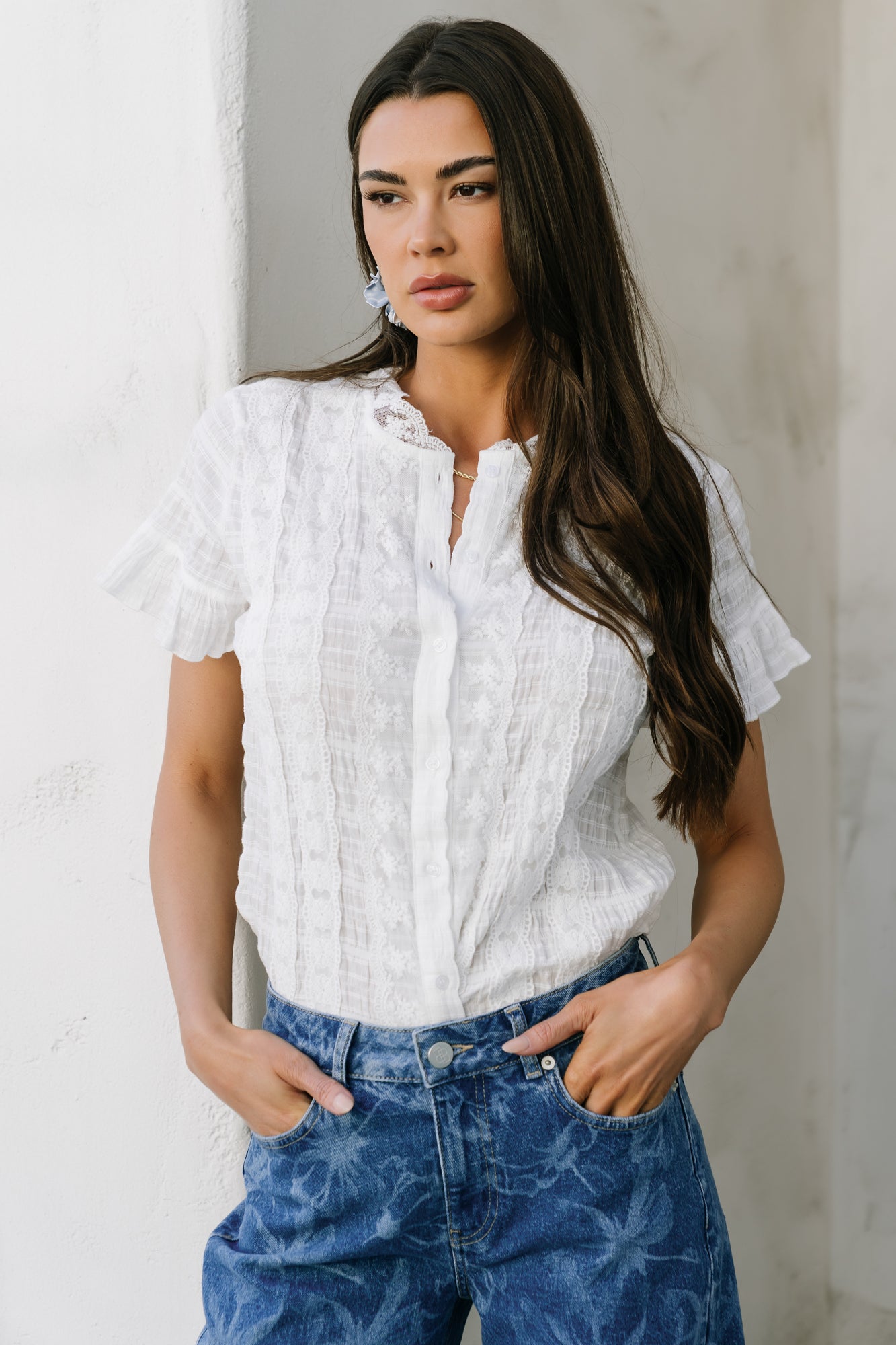 Side-angle of model wearing the Zara Lace Top illustrating short ruffle sleeves, unlined silhouette, and how the textured cotton drapes on the body.