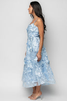 Detail of square neckline with silicone grip and adjustable tank strap hardware on light blue mesh fabric.