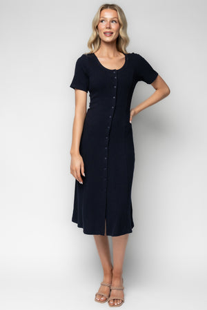Three-quarter view of Océane navy midi dress on model, showing fitted bodice, princess seams, ribbed texture, and buttons down the front.