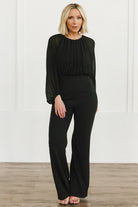 Front view of Serene Blouse Jumpsuit in true black on model, showing chiffon blouse, round neckline, fitted bodice and relaxed straight trousers.