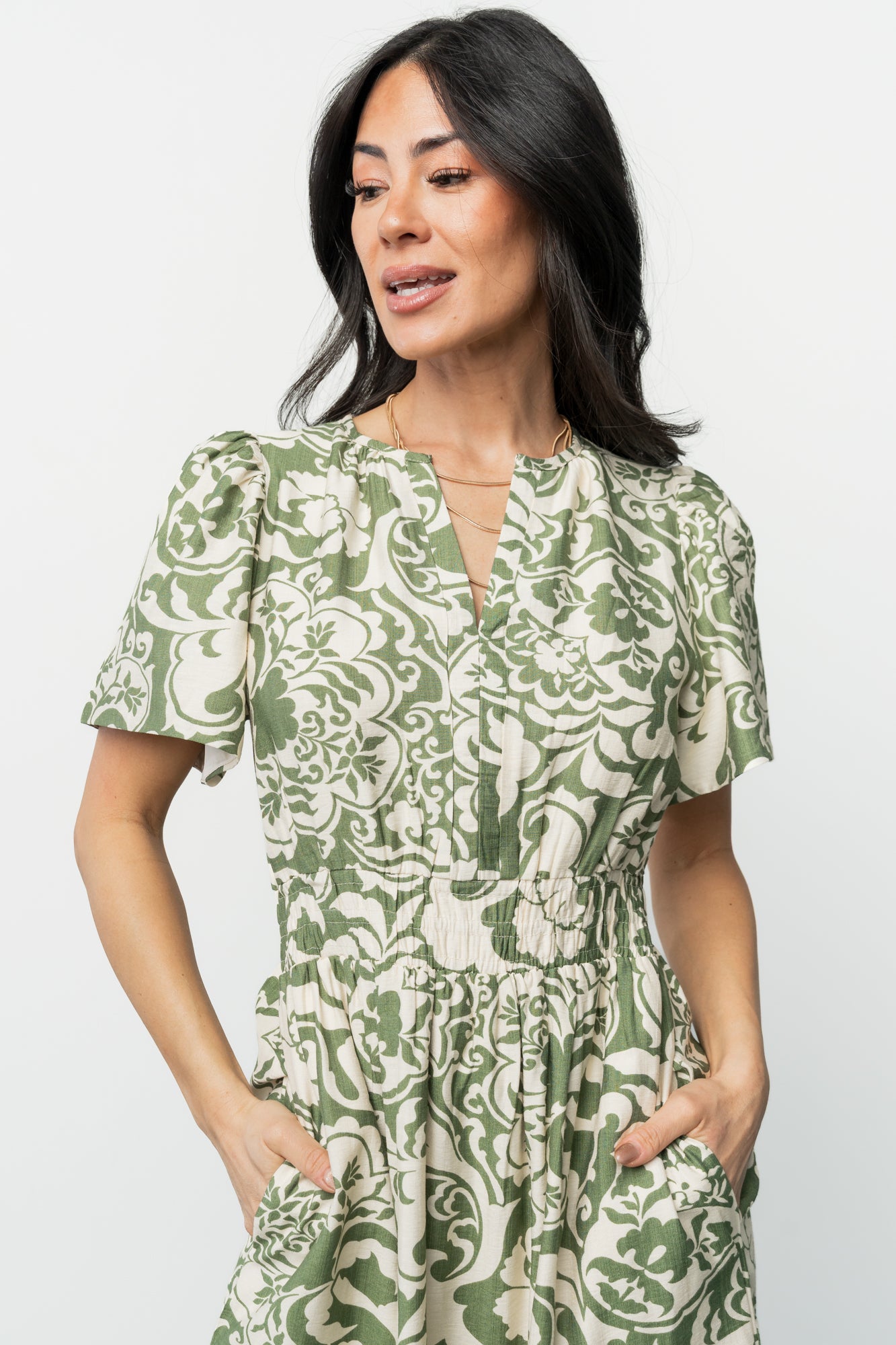 Detail shot of smocked waistband and side seam with pocket opening, illustrating stretch and functional pocket placement.