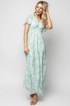 Three-quarter angle of Soline Maxi Dress in light teal floral, highlighting burnout velvet texture, chiffon layers, and gentle drape at the hem.