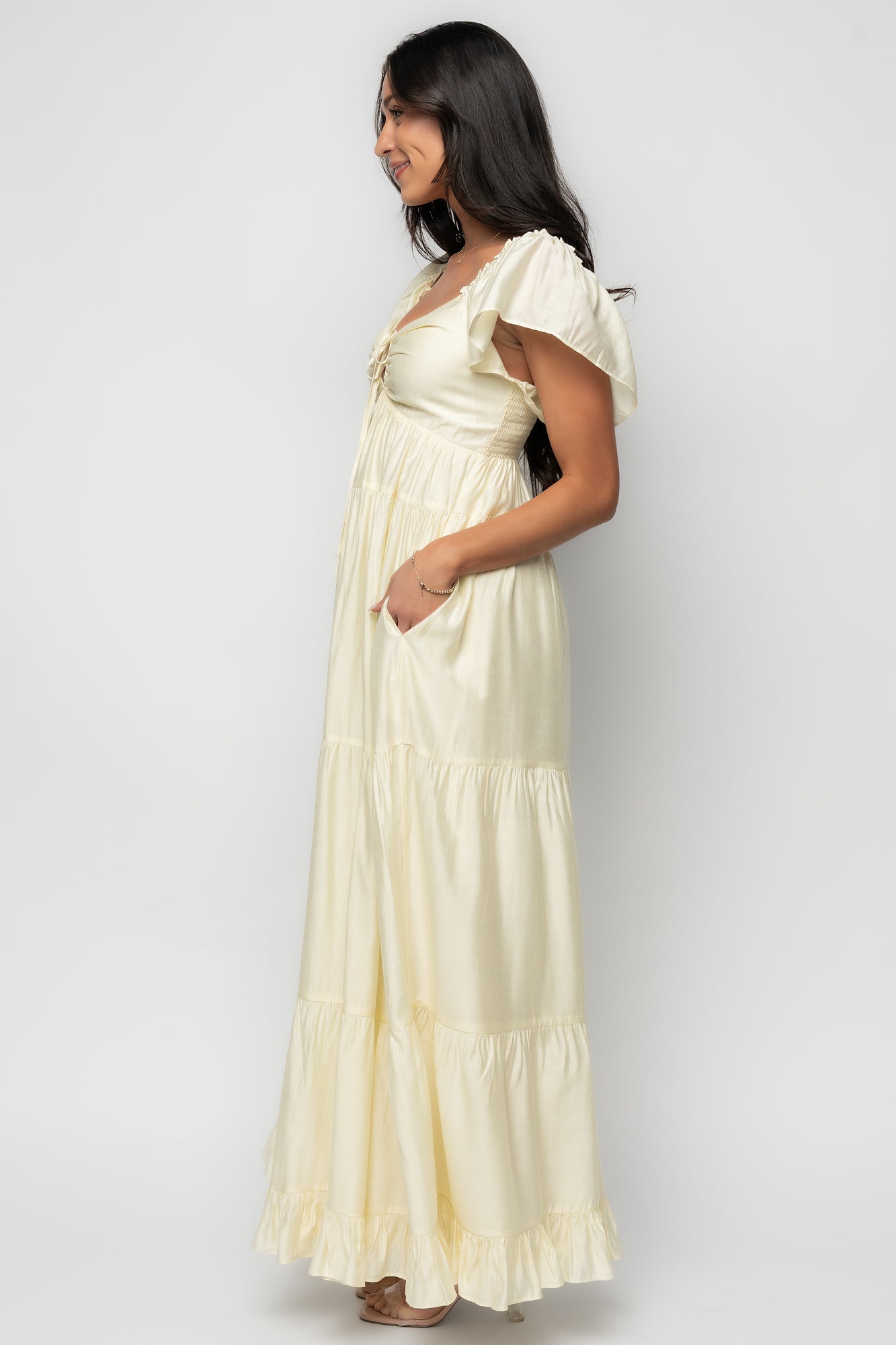 Model movement shot wearing the pale yellow Agatha Maxi Dress, showing tiered skirt flow, ruffle sleeves, and overall silhouette.