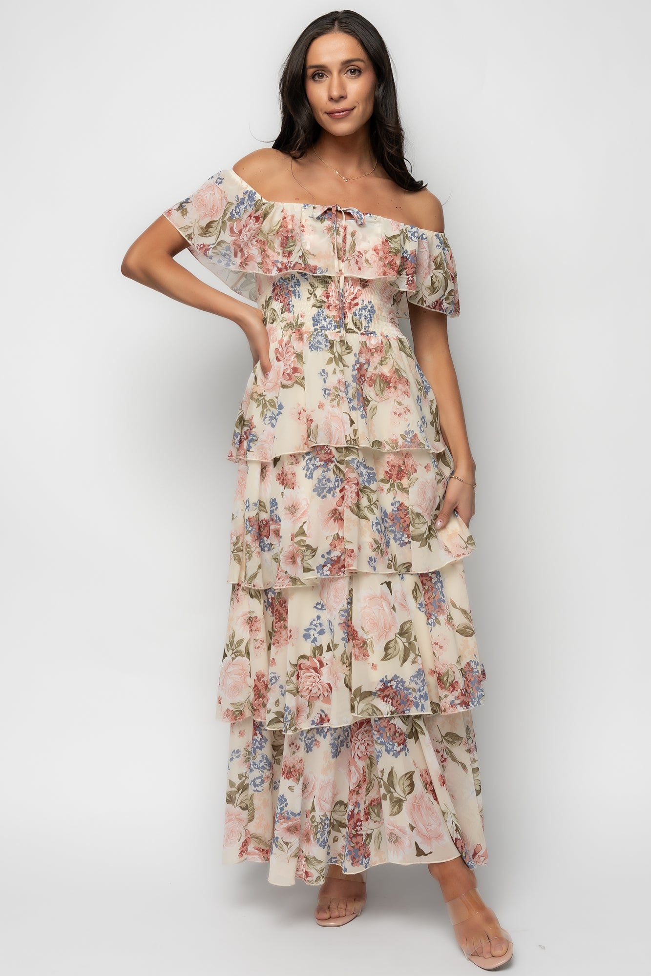 Model wearing multi floral off-shoulder maxi showing single tiered bust ruffle and flattering smocked waist; lightweight chiffon drape visible.