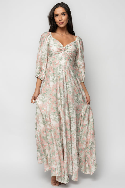 Model wearing Esther Maxi Dress in sage + blush floral; shows the twist-knot bust detail, up-pointed paneled waist and the dress's full length silhouette.
