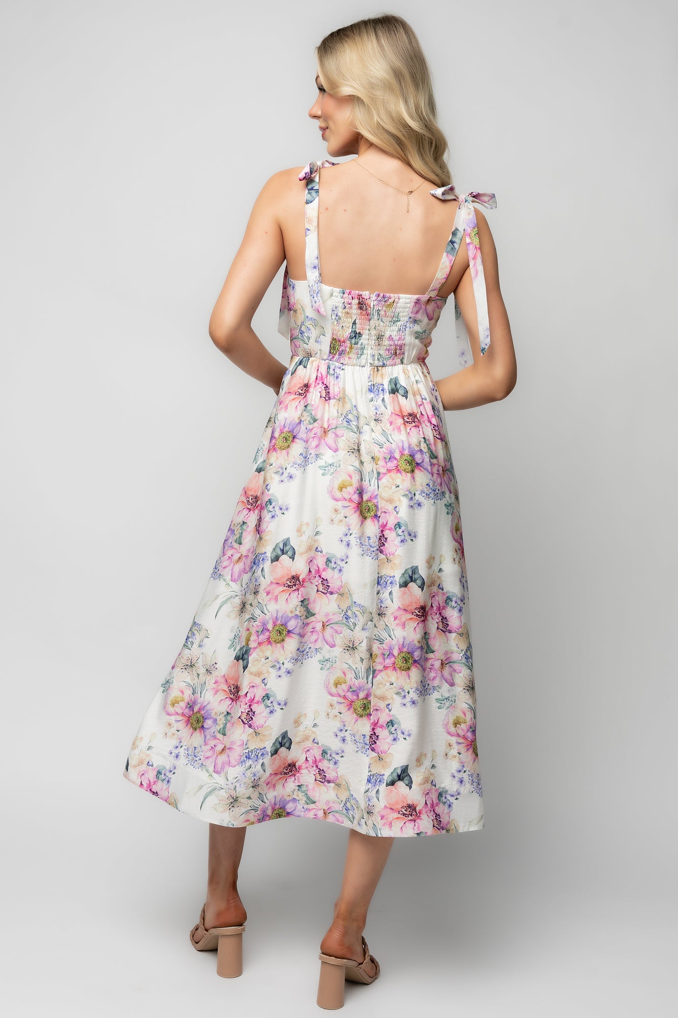 Lifestyle image of Opaline Midi Dress styled with sandals, showcasing movement, hem structure, and floral pattern.
