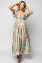 Close-up of the Eliana Maxi Dress neckline showing the elastic ruffle detail, adjustable tie at the bust, and the soft rayon fabric texture with rose-pink floral motif.