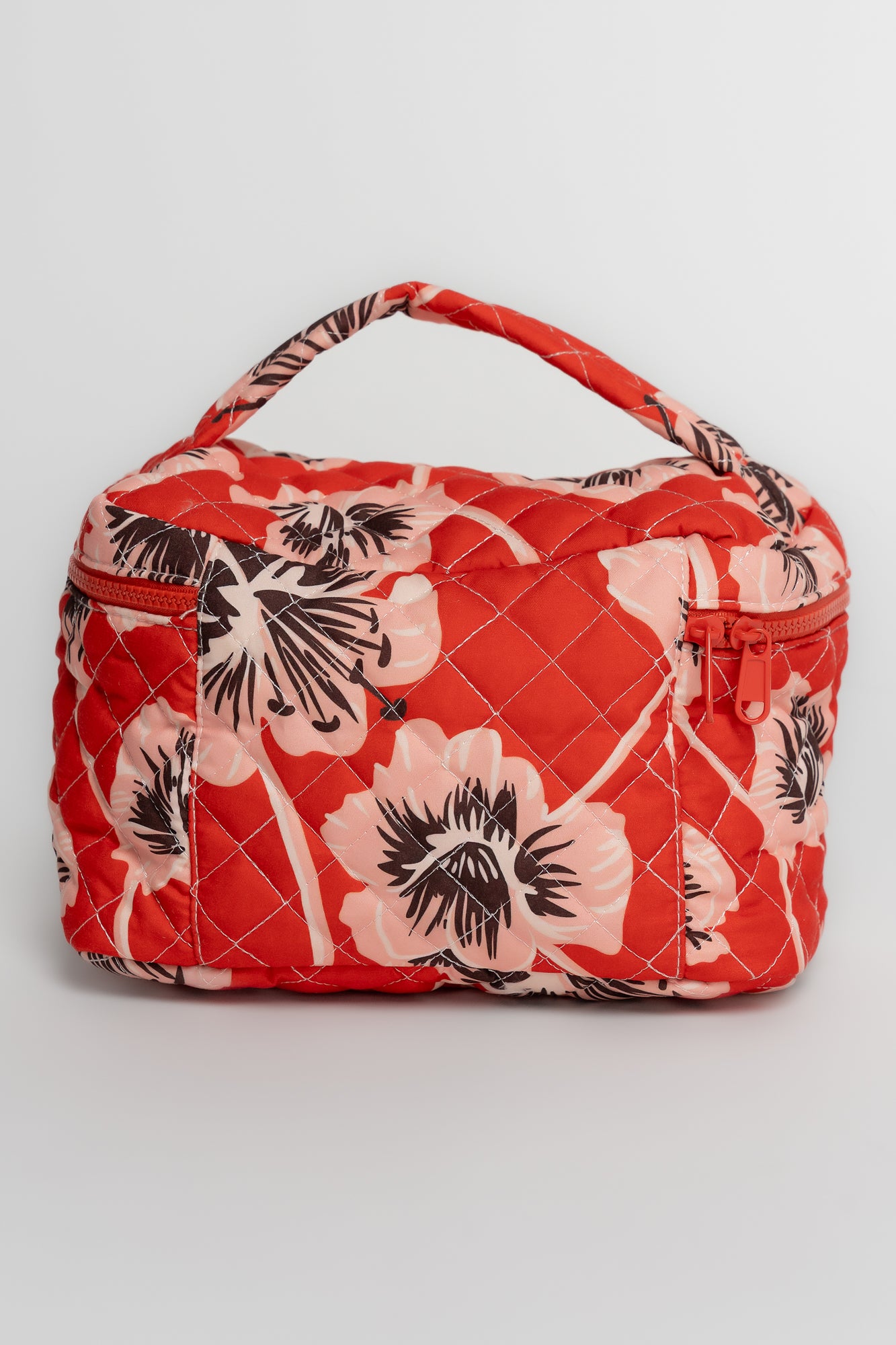 Close-up of the quilted exterior and stitching on the Sunset Floral cosmetic bag, showing fabric texture and pattern detail.