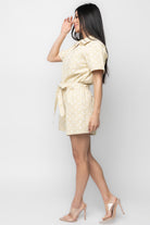 Three-quarter view of the romper showing polka-dot pattern, waist tie detail, and the overall fit on the model.