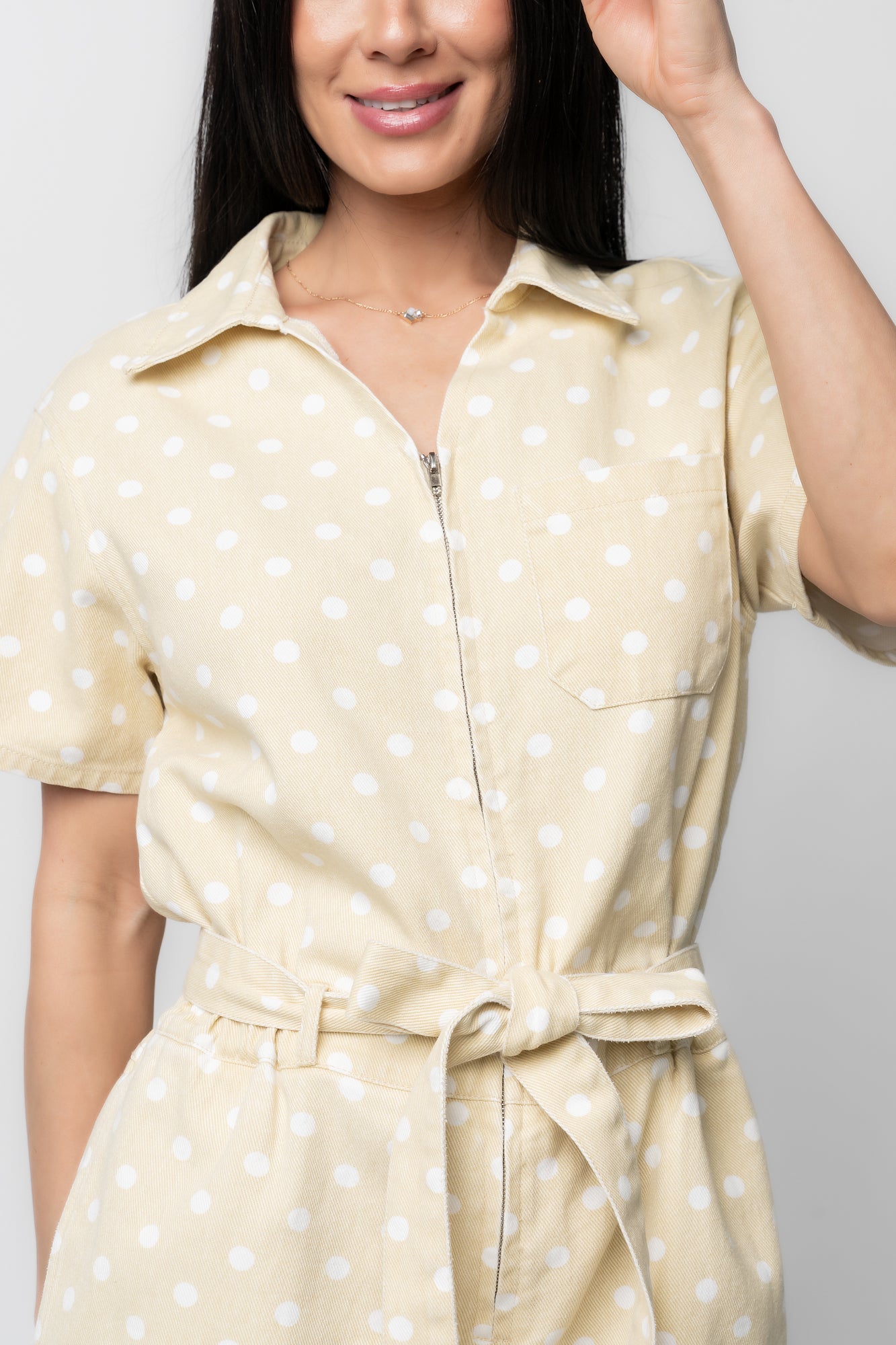 Side profile of Korra romper highlighting short sleeves, elastic waist with removable tie, and a relaxed silhouette with side pockets.