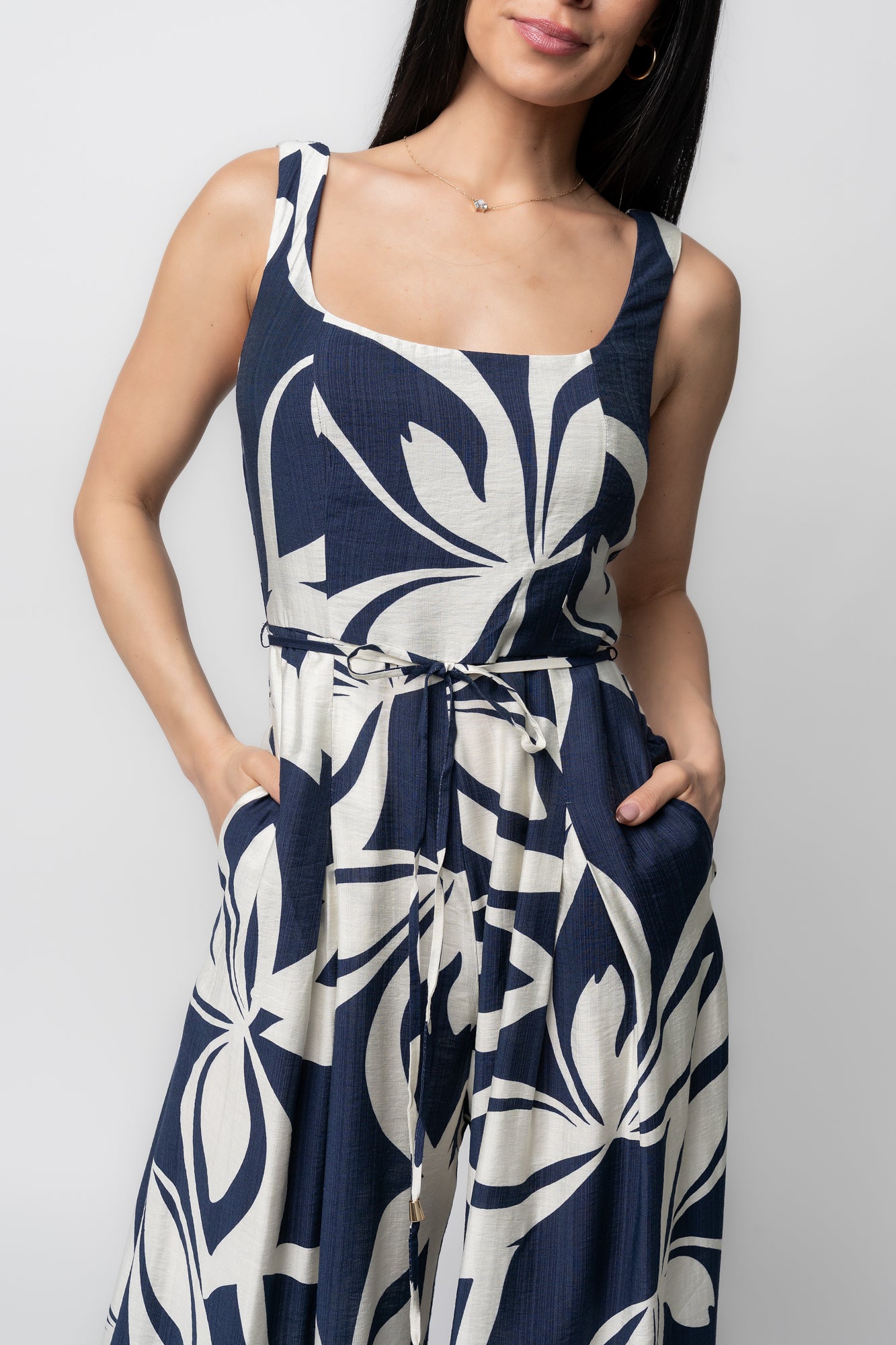 Back view of Manuela jumpsuit in navy abstract print on model, showing back zipper closure and the wide pleated leg silhouette with movement.