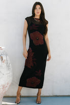 Rear and side view of Daniela dress showing mesh overlay drape, fitted bodycon shape, and maroon floral placement on black base.