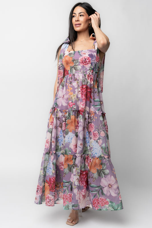 Front view of Anita Maxi Dress in lavender multi floral print on model; square neckline, smocked bodice, and flowing tiered chiffon skirt showcasing full length.