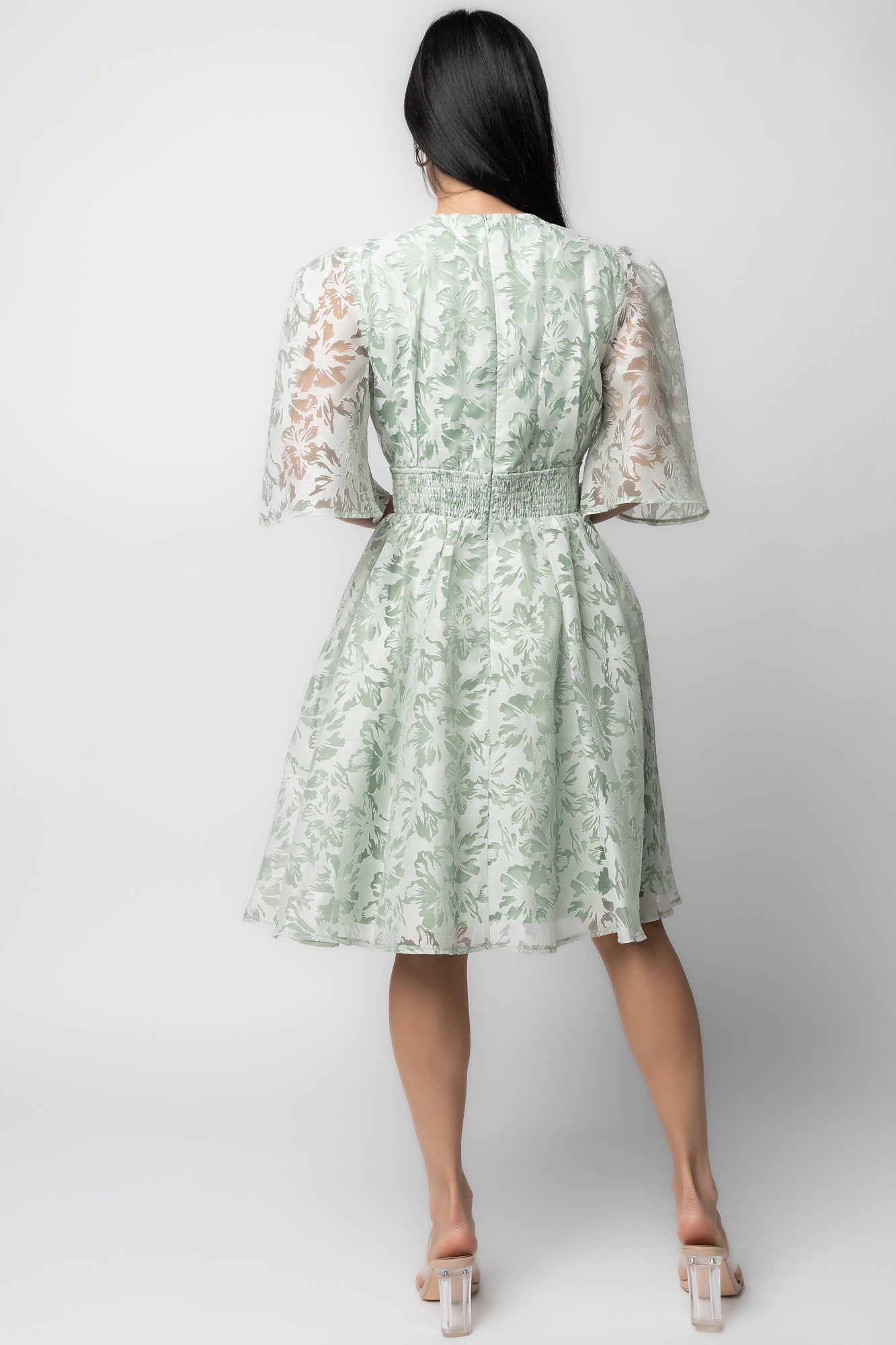 Close-up of floral jacquard fabric on the Bonnie Short Dress, displaying textured weave and embroidered floral pattern in light sage tones.