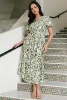 Close-up of fabric and print showing ivory background with green floral motifs and subtle linen-like rayon texture and stitching detail.