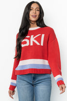 Front view of red multi Gilli ski sweater with ski graphic, round neckline and drop shoulders; knit texture clearly visible on the body.