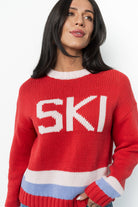 Detail view of the round neckline and cuff of the red multi Gilli ski sweater, illustrating the comfortable ribbing and knit construction.